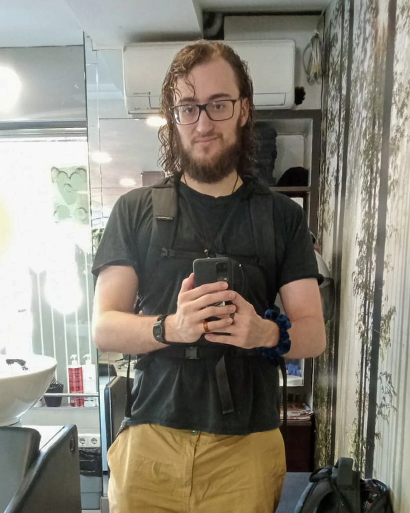 Before: Mirror selfie at a barber shop. Backpack still on.